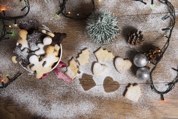 christmas cookies on wooden table with ornaments and pinecone