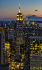 City skyline and Empire State Building at night in NYC, USA