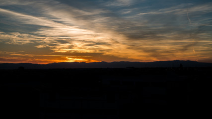 Mountains Silhouette Dramatic Sunset Sky over city, with Wonderful Colors