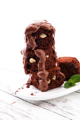 Cake chocolate brownies with dark chocolate dressing and mint on wooden table.