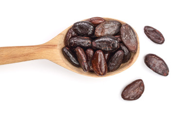 cocoa bean in a wooden spoon isolated on white background close-up top view