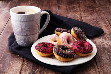 donuts and coffee for a sweet breakfast on wooden background.