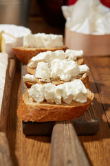 Cheese, vegetables, fruits and spices. Bread, olives and crackers. Mediterranean diet and cuisine. Dark background. Top view.