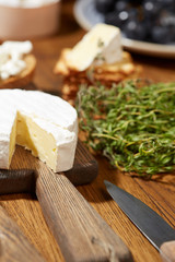 Cheese, vegetables, fruits and spices. Bread, olives and crackers. Mediterranean diet and cuisine. Dark background. Top view.