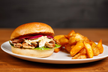 Pulled pork burger with cole slaw and country potatoes, wedges and ketchup, close up