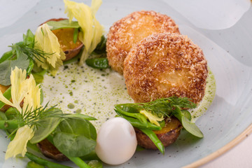 Fish pike perch cutlets with fried potatoes in sour cream sauce with dill oil and quail egg