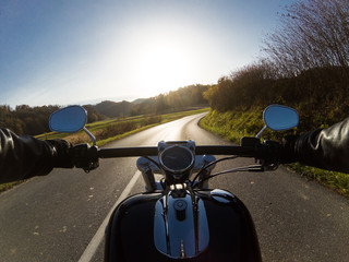 Fototapeta premium Zdjęcie z pierwszej osoby przedstawiające motocyklową przygodę na wsi
