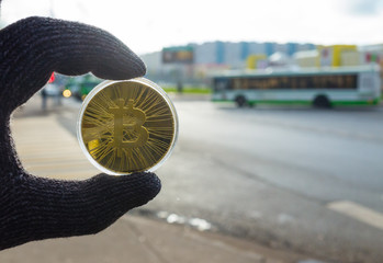 Gold bitcoin on the background of automobile traffic