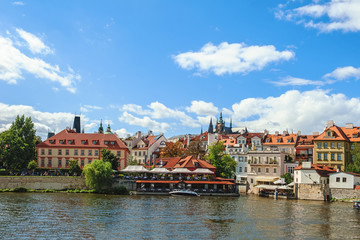 Obraz premium Beautiful view from the river Vltava on the Bank of Prague on a Sunny day with a dramatic sky.