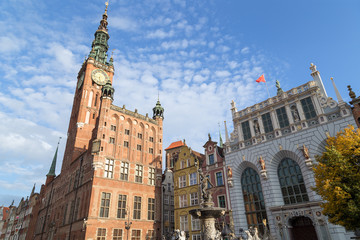 View of the Neptune Fountain, Artus Court, Main Town Hall and other old buildings at Long Market Street (Long Lane) at the Main Town (Old Town) in Gdansk, Poland, on a sunny day.