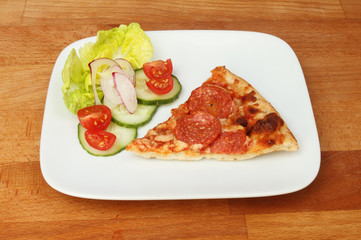 Pizza and salad on a tabletop