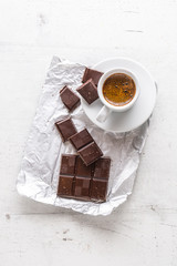 Coffee and dark chocolate. Top of view cup of coffee with dark chocolate