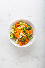 Top of view mixed vegerable carrot broccoli and cauliflower in bowl on white concrete background