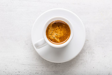Top of view cup of coffee on white concrete background