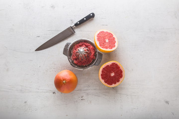 Top of view Grapefruit knife and juicer on white concrete background