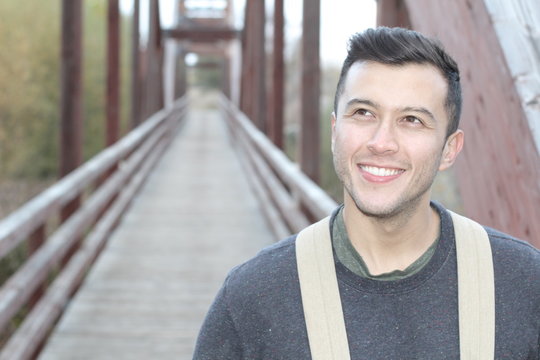 Smiley male walking through a bridge