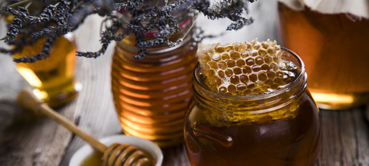 Fototapeta na wymiar Honey in jar with honey dipper on wooden background 