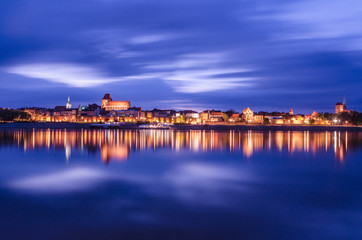 Torun at night. UNESCO-class medieval Old Town reflected in Vistula river, Poland. Europe. - obrazy, fototapety, plakaty
