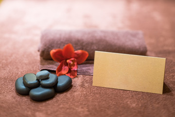 Lily, stones, towel in spa saloon. Gift card.