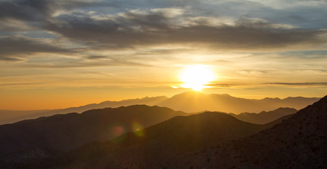 Obraz premium Panoramiczny widok zachodu słońca nad pustynnym krajobrazem górskim Joshua Tree National Park w Kalifornii