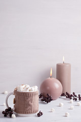 Hot chocolate drink with marshmallows and candles for cold weather. Christmas celebration or cold winter concept with copy space