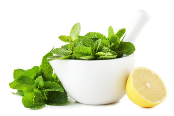 Fresh mint leafs in mortar with lemon on white background
