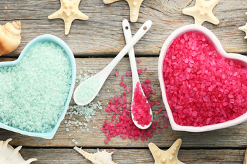 Sea salt in bowls with seashells on grey wooden table