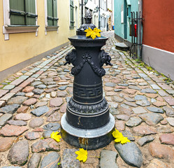 Narrow street in old Riga that is the capital of Latvia and famous tourist city in Baltic region where everyone can feel unforgettable atmosphere of Middle Ages and unique Gothic architecture