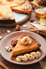 Sweet piece of pumpkin tart in plate on wooden table