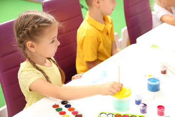 Little children at painting lesson in classroom