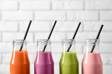 Bottles with yummy smoothie on light background