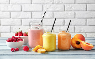 Composition with jars of yummy smoothie on wooden table