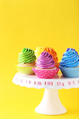 Tasty cupcakes on a yellow background