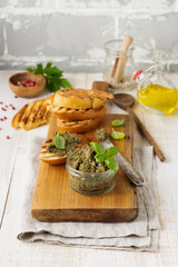 Tapenade, traditional Provence dish with black and green olives, basil and bread on old wooden table background. Selective focus.
