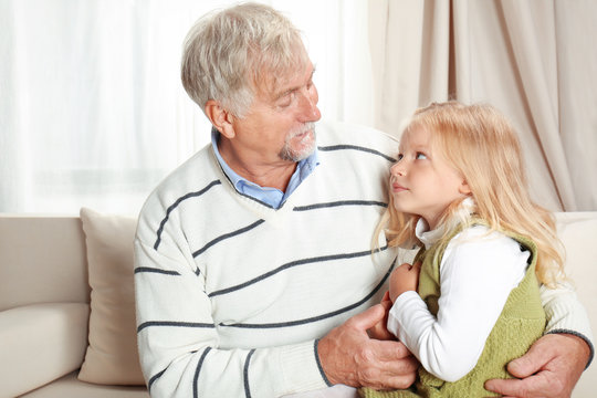Elderly man with granddaughter at home