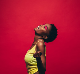 Cheerful young woman dancing in studio
