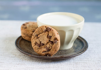 Cup of hot milk and homemade chocolate chip cookies