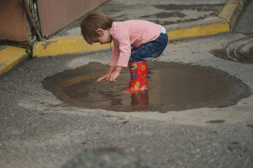 girl plays in the puddle outdoors