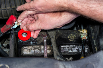 Man adds a corrosion resistant pad to a car battery