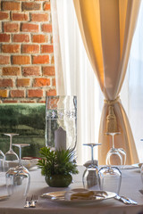 Table set with candles in a luxurious restaurant with brick wall background