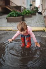 girl plays in the puddle outdoors