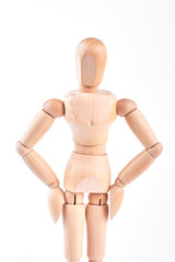 Wooden dummy with hands on hips. Wooden mannequin standing on white background. Wooden human dummy.