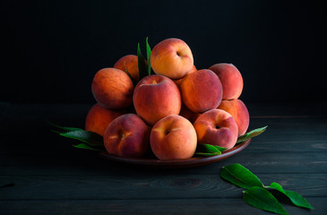 Many sweet peaches in a plate on the table