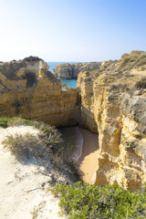 Einsamer Strand umringt von Felsen an der Algarve