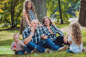 Fototapeta premium Young family with cheerful children in the park