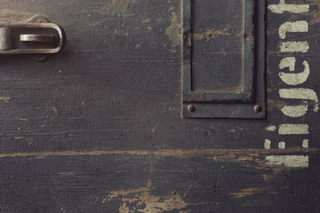 Texture of an old wooden case for military equipment with metal fittings and a part of a stenciled...