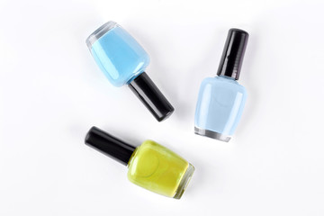 Colorful nail varnishes on white background. Nail polish set isolated on white background. Blue and yellow nail varnish.