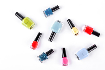 Collection of nail polish, top view. Set of different nail varnish lying on white background. Nail beauty studio.