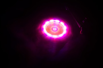 Turntable playing vinyl with glowing abstract lines concept on dark background. Selective focus