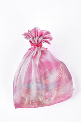 Pink organza bag with jewelry. Pink sack for keeping jewelry, white background. Pouch with jewely on white background.